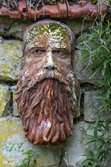 France, Giverny. Stone face hanging on a stone wall. Credit as France, Giverny. Stone face hanging on a stone wall. Credit as