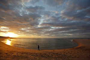 A girl walks on the beach a the sun sets over Head of the Meadow Beach at the Cape A girl walks on the beach a the sun sets over Head of the Meadow Beach at the Cape