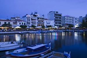 GREECE-CRETE-Lasithi Province-Agios Nikolaos: View of the Cafes by Voulismeni Lake / Dusk GREECE-CRETE-Lasithi Province-Agios Nikolaos: View of the Cafes by Voulismeni Lake / Dusk