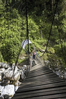 Hikers are crossing river Mobuku with the help of the old Kurt Shafer Bridge Hikers are crossing river Mobuku with the help of the old Kurt Shafer Bridge