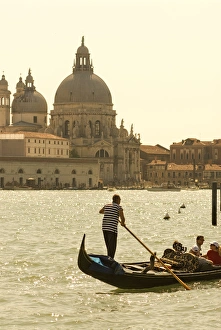 Italy; Venice. A gondolier ferries tourists on the Grand Canal in Venice with the massive church Italy; Venice. A gondolier ferries tourists on the Grand Canal in Venice with the massive church
