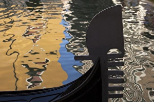 Italy, Venice. The silhouette of a gondola against a background of colorful water Italy, Venice. The silhouette of a gondola against a background of colorful water