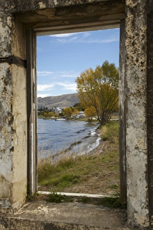 Looking through window of derelict building to Lake Dunstan and Old Cromwell Town Looking through window of derelict building to Lake Dunstan and Old Cromwell Town