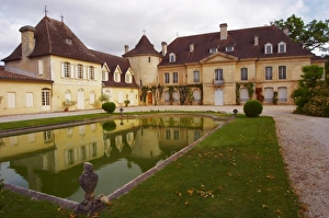 The main chateau building with its tower and a pond showing a reflection Chateau The main chateau building with its tower and a pond showing a reflection Chateau