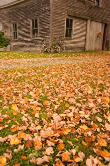 Maine, Old wooden barn with wagon wheels in fall in rural New England Maine, Old wooden barn with wagon wheels in fall in rural New England