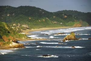 Mexico, Mazunte, scenic view of sea with houses on green mountain in background against Mexico, Mazunte, scenic view of sea with houses on green mountain in background against