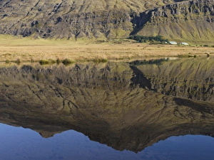 Mountain and homestead reflection in Lake, Iceland Mountain and homestead reflection in Lake, Iceland