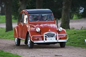 An old red Citroen 2CV car with a smiling woman driving, Elisa Trabal de Bouza owner An old red Citroen 2CV car with a smiling woman driving, Elisa Trabal de Bouza owner
