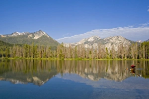 Paddling a sea kayak on a calm Pettit Lake in the Sawtooth Mountains of Idaho (MR) Paddling a sea kayak on a calm Pettit Lake in the Sawtooth Mountains of Idaho (MR)