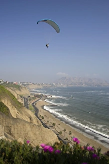 Parasailor soars over cliffs and ocean in Miraflores neighborhood, Lima, Peru Parasailor soars over cliffs and ocean in Miraflores neighborhood, Lima, Peru