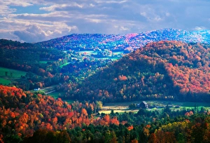 On a partly cloudy day in the fall, the sun has illuminated some hills more than On a partly cloudy day in the fall, the sun has illuminated some hills more than