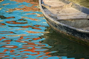 Rowboats float in water reflecting distinctive red and blue fishing boats, Nha Trang Rowboats float in water reflecting distinctive red and blue fishing boats, Nha Trang