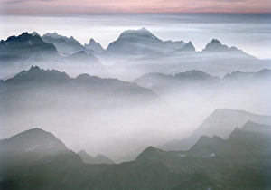 The rugged peaks of North Cascades National Park seen through mist with a band of The rugged peaks of North Cascades National Park seen through mist with a band of