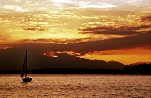 A sailboat sails into the setting sun on Seattles Elliot Bay A sailboat sails into the setting sun on Seattles Elliot Bay