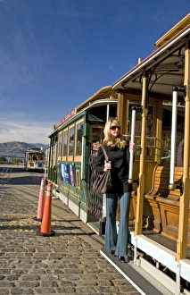 San Francisco pretty blond female in sunglasses holding on to cable car at Friedel San Francisco pretty blond female in sunglasses holding on to cable car at Friedel