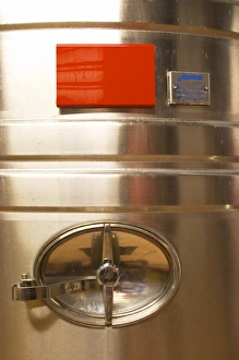 A detail of a stainless steel wine fermentation tank with the opening. The winery is designed A detail of a stainless steel wine fermentation tank with the opening. The winery is designed