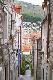 A steep street leading down from the city wall to the city and a view over rooftops A steep street leading down from the city wall to the city and a view over rooftops