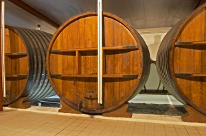 A storage room in the winery with old wooden foudres (large wooden barrels) Chateau A storage room in the winery with old wooden foudres (large wooden barrels) Chateau