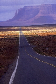 Straight road with desert waves heading for Monument Valley, Utah Straight road with desert waves heading for Monument Valley, Utah