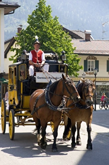 Street scene with a horse drawn stage coach in the alpine village of Garmisch, Germany Street scene with a horse drawn stage coach in the alpine village of Garmisch, Germany
