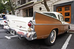A Studebaker Silver Hawk Classic Car parked on a street, painted in cream white and brown A Studebaker Silver Hawk Classic Car parked on a street, painted in cream white and brown