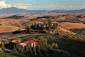 Sunset light on rolling agricultural hills of Tuscany after the harvest, San Quirico Sunset light on rolling agricultural hills of Tuscany after the harvest, San Quirico