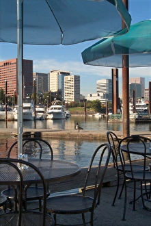 Tables with green umbrellas at a restaurant on the Willamette River, with the Portland Marina Tables with green umbrellas at a restaurant on the Willamette River, with the Portland Marina