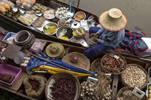 Thailand, Amphawa Floating Market. Woman prepares food for customer in her dugout canoe shop Thailand, Amphawa Floating Market. Woman prepares food for customer in her dugout canoe shop
