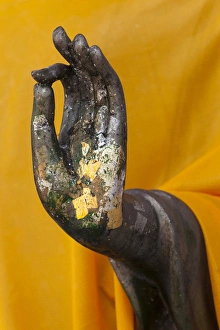 Thailand. Buddha Statue hand with gold leaf tokens Thailand. Buddha Statue hand with gold leaf tokens