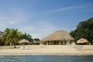 Thatched palapas, cabana and lounge chairs on beach, viewed from Caribbean Sea Thatched palapas, cabana and lounge chairs on beach, viewed from Caribbean Sea