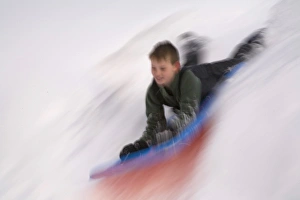 United States, Washington, Crystal Mountain, boy on sled in motion (MR) United States, Washington, Crystal Mountain, boy on sled in motion (MR)