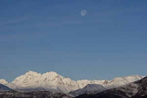 USA, Alaska, Full moon above Chugach Range mountain peaks in early winter USA, Alaska, Full moon above Chugach Range mountain peaks in early winter