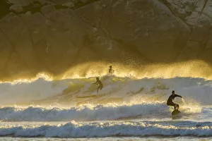 USA, California, San Luis Obispo County. Surfers at sunset USA, California, San Luis Obispo County. Surfers at sunset