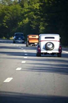 USA, Maine. Three antique cars traveling on a modern highway USA, Maine. Three antique cars traveling on a modern highway