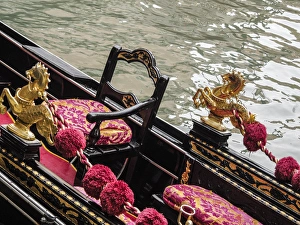Venice, Italy. Gondola interior adorned with a golden horse serpent, velveteen cushions Venice, Italy. Gondola interior adorned with a golden horse serpent, velveteen cushions