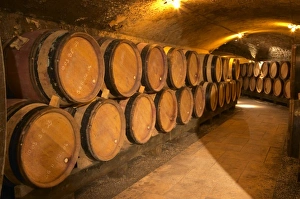 Wooden barrels with aging wine in an underground corridor in the cellar of Guigal in Ampuis Wooden barrels with aging wine in an underground corridor in the cellar of Guigal in Ampuis