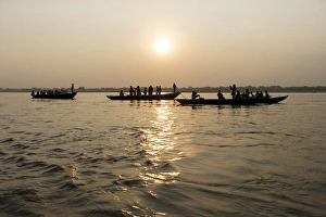 Three wooden boats filled with tourists at sunrise on Ganges river, Varanasi, India Three wooden boats filled with tourists at sunrise on Ganges river, Varanasi, India