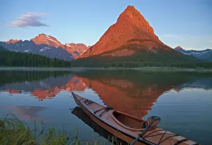 Wooden kayak in Swiftcurrent Lake at sunrise in the Many Glacier Valley of Glacier National Park Wooden kayak in Swiftcurrent Lake at sunrise in the Many Glacier Valley of Glacier National Park