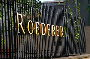 Wrought iron fence with golden letters shining in the setting sun at Champagne Louis Wrought iron fence with golden letters shining in the setting sun at Champagne Louis
