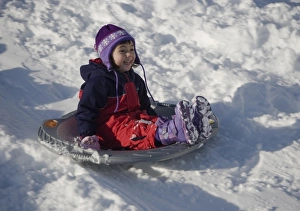 Four year old girl sledding in the winter at Mt. Rainier National Park, Washington. (MR) Four year old girl sledding in the winter at Mt. Rainier National Park, Washington. (MR)