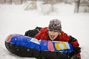 A young boy sledding on a snow tube during a snowstorm in Portsmouth, New Hampshire A young boy sledding on a snow tube during a snowstorm in Portsmouth, New Hampshire
