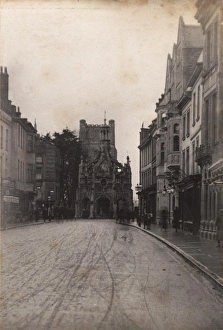 Prints of Taken from East Street, showing the fronts of shops and business along East Street and the Cathedrals bell tower in the background John Fletcher Collection West Sussex Record Office Chichester Prints: Chichester Print: Early 20th-Century Street Scene with Cathedral Bell Tower
