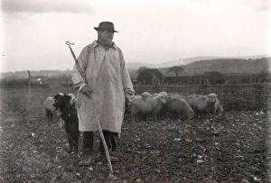 Shepherd wearing a smock with his dog and sheep, January 1925 Shepherd wearing a smock with his dog and sheep, January 1925