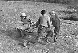 Images Dated 1st June 2006: Farm children playing on a homemade merry-go-round. Photograph, 1937, by Russell Lee