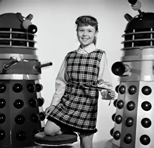 A portrait of a smiling Roberta Tovey as Susan with Daleks A portrait of a smiling Roberta Tovey as Susan with Daleks