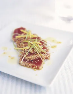 Chilled seared tuna with ginger and spring onion dressing (Katsuo tataki) sprinkled with sesame seeds on white plate Chilled seared tuna with ginger and spring onion dressing (Katsuo tataki) sprinkled with sesame seeds on white plate