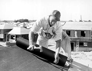 Construction worker working on roof of house Construction worker working on roof of house