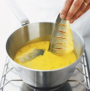 Dropping sea bass fillets in curry sauce (meen molee) Dropping sea bass fillets in curry sauce (meen molee)