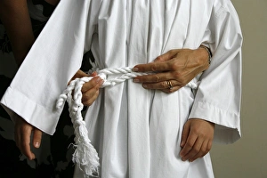 Mother dressing her son for his first holy communion Mother dressing her son for his first holy communion