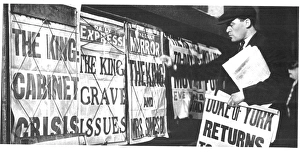 Newspaper seller adjusting his headline posters Newspaper seller adjusting his headline posters